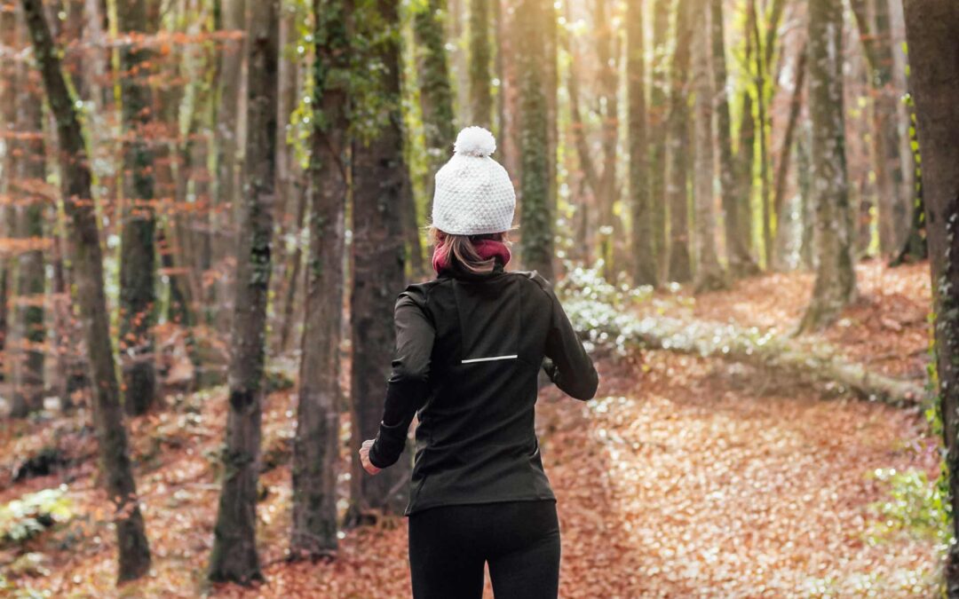 A woman running in the woods in early spring
