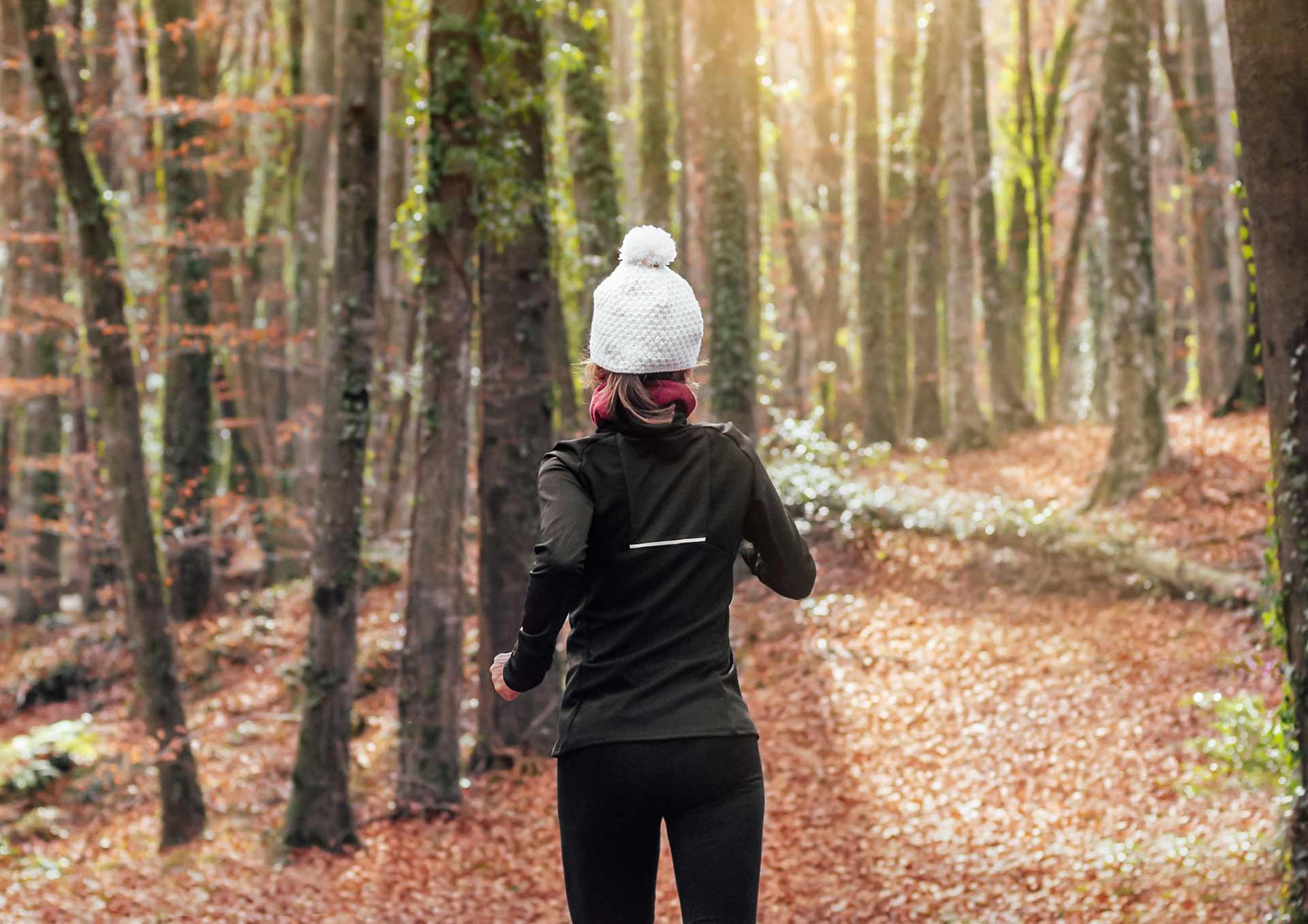 A woman running in the woods in early spring