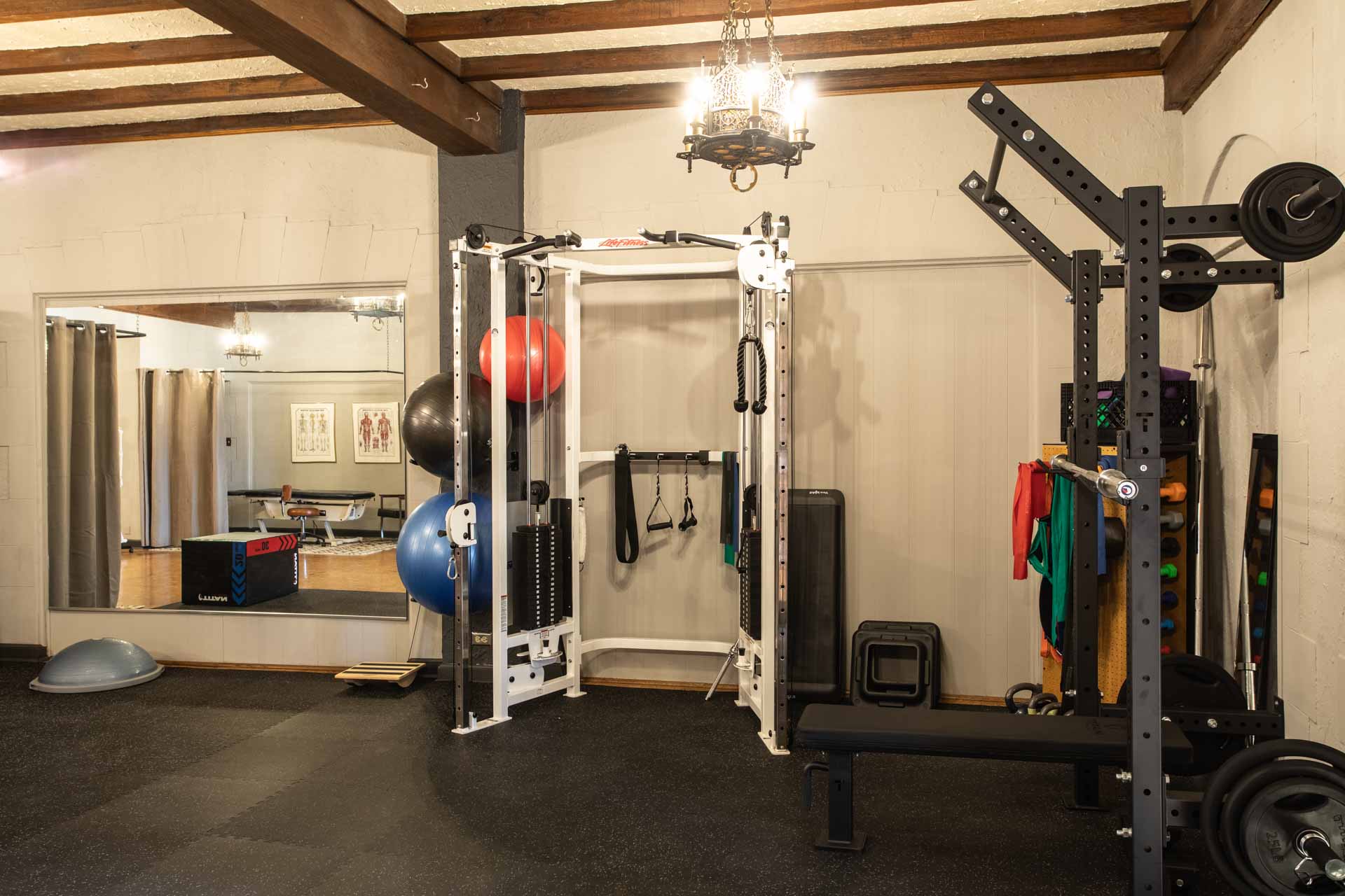A second view of the cable machine and squat rack at MKE Physical Therapy
