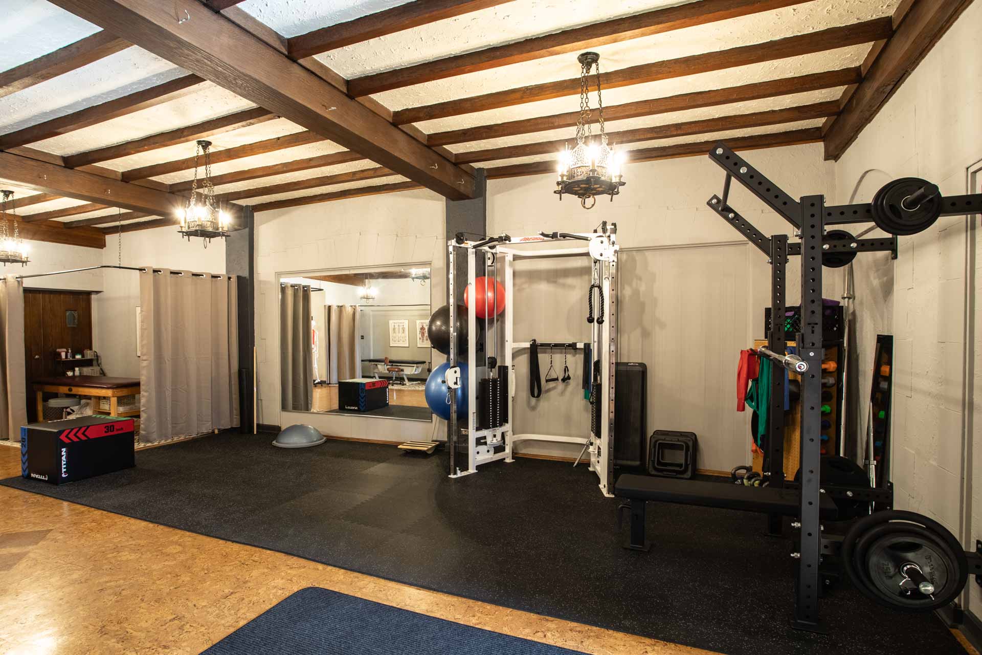 A wide angle photo of the cable machine and squat rack at MKE Physical Therapy